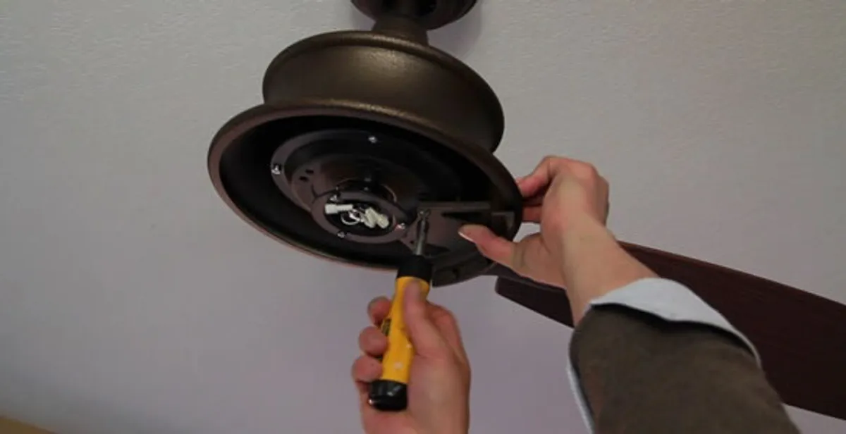 Electrician installing ceiling fan mounting bracket and fixture in Indianapolis, IN