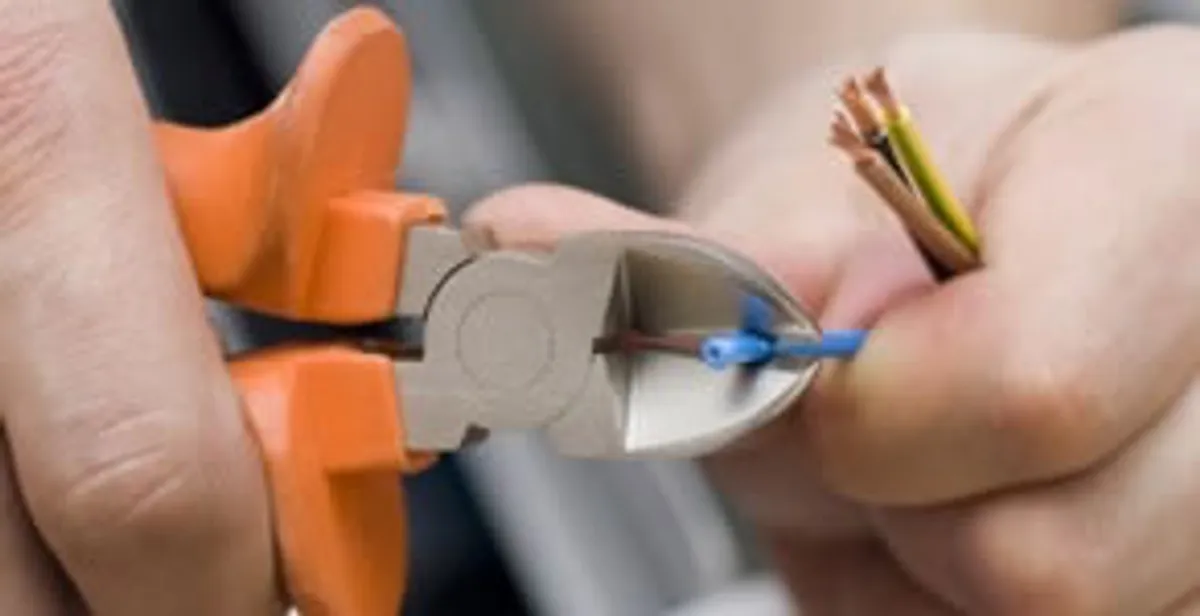 licensed electrician performing precise wire cutting and preparation during electrical service in Indianapolis, IN